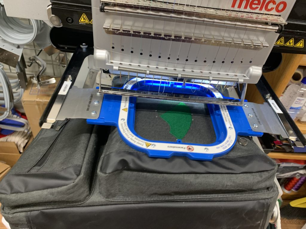 image shows an embroidery machine in operation